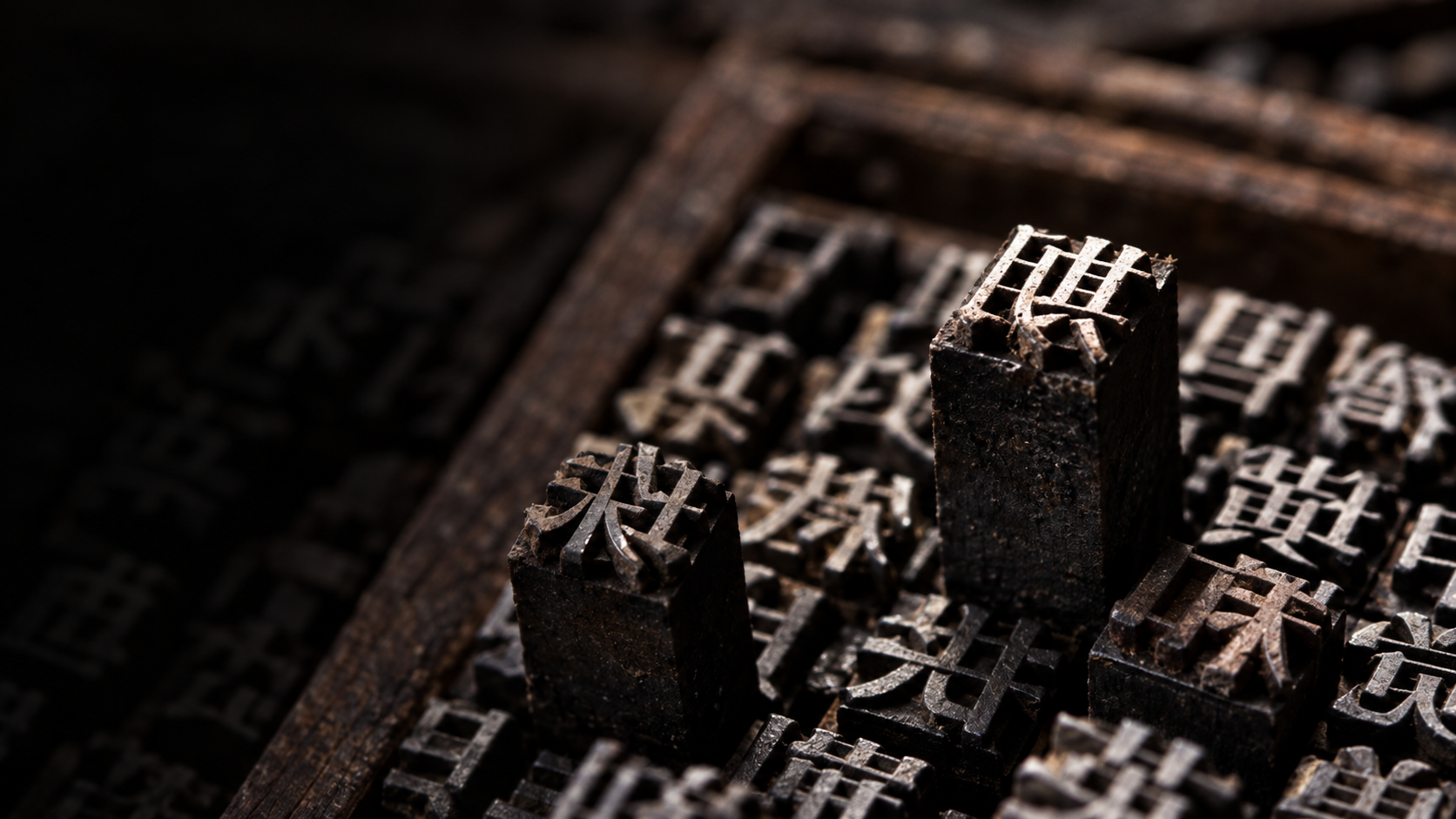 墨黑活字字块的凸起字面、木纹与磨损边缘特写